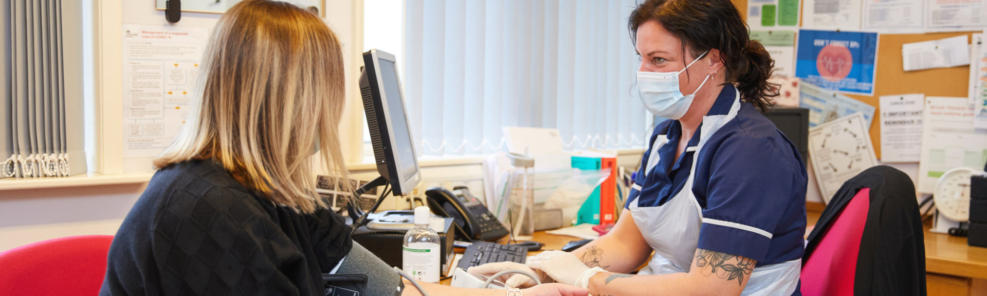 A photo showing a nurse taking a patients blood pressure